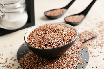 Bowl with flax seeds on light background, closeup