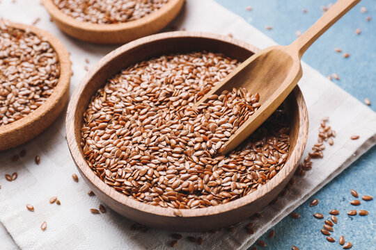 Composition with bowls of flax seeds on color background, closeup