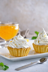 Tartlets with orange jam and protein cream decorated with orange zest on a white plate