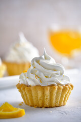 Tartlets with orange jam and protein cream decorated with orange zest on a white plate