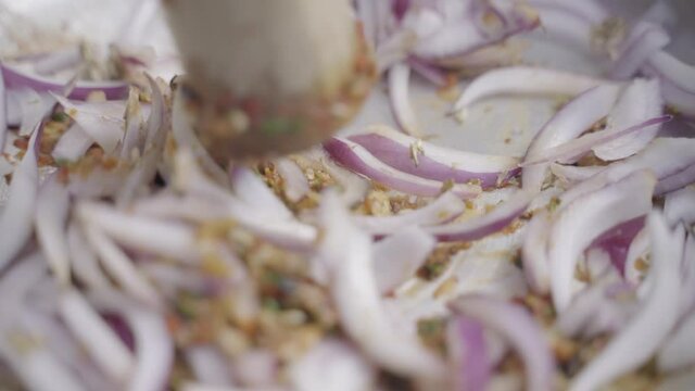 Close-up: Raw red pepper is mixed in bowl with peppers, garlic, ginger