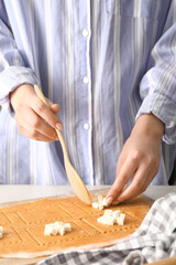 Female chef making delicious ravioli at table, closeup