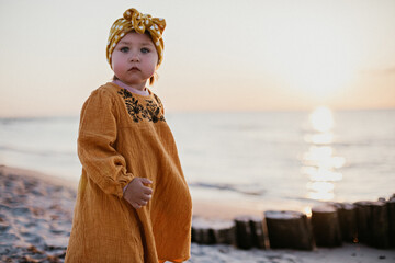 Beautiful little girl on sunset beach