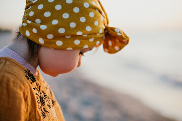 Close-up portrait of little girl on sunset beach