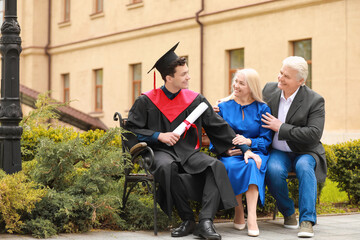 Happy young man with his parents on graduation day