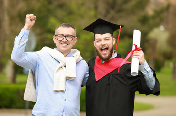 Happy young man with his father on graduation day