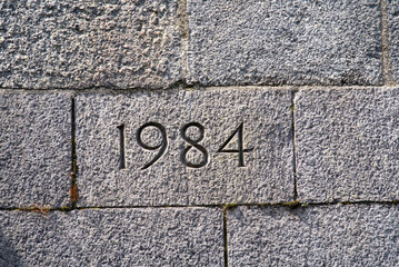 Stone wall of bridge foundation with year 1984 engraved. Photo taken June 13th, 2021, Zurich, Switzerland. - obrazy, fototapety, plakaty
