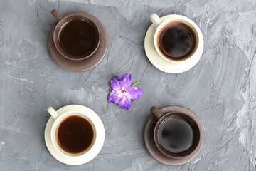 Top view of different types of coffee in black and white cups and a decorative flower