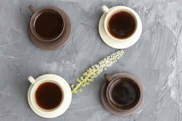 Top view of different types of coffee in black and white cups and a decorative flower