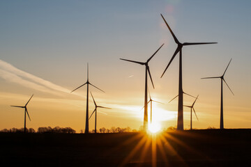 Silhouettes of wind turbines in the rising sun