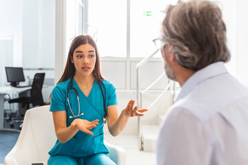 Fototapeta premium Doctor consulting patient in hospital waiting room. Patient sitting . Diagnostic, prevention of diseases, healthcare, medical service, consultation or education, healthy lifestyle concept