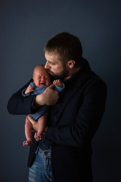 Dad Holds A Crying Newborn In His Arms. Happy Childhood, Selective Focus.