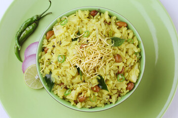 Indian Breakfast Dish Poha Also Know as Pohe or Aalu poha made up of Beaten Rice or Flattened Rice. The rice flakes are lightly fried in oil with mustard, turmeric, onion, curry leaves