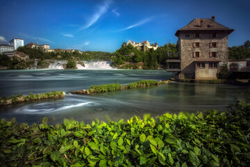 Fototapeta na wymiar View to Rhine falls (Rheinfalls), the largest plain waterfall in Europe. It is located near the town of Schaffhausen in northern Switzerland, between the cantons of Schaffhausen
