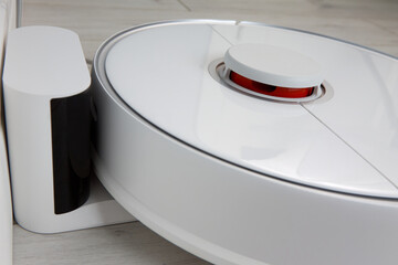 Close-up of the automatic charging of the robot vacuum cleaner. Smart Home Concept