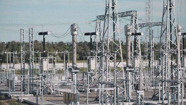 Switchyard of contemporary electricity distribution substation with different power equipment in field on sunny summer day