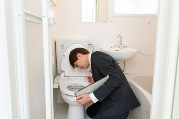 住宅リフォーム　トイレの便器を調査するビジネスマン