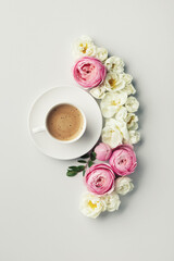 Cup of coffee and beautiful composition with pink and white rose flowers. Top view and flat lay style.