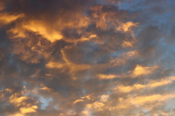 Naklejka na ściany i meble Cloudy sky at sunset on a spring evening as a background.