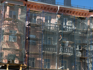 Scaffolding around the building, workers restoring the facade of the old building.