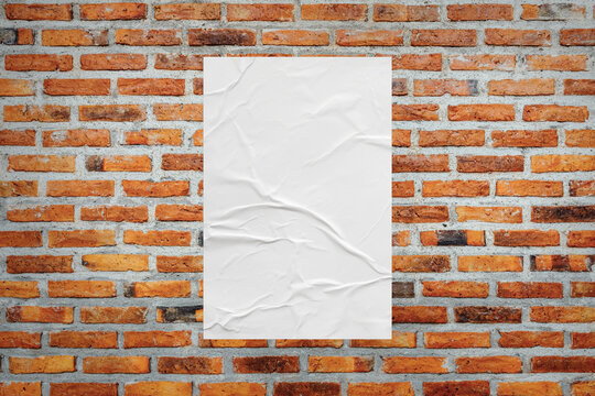 Blank white wheatpaste glued paper poster mockup on brick wall background