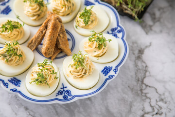 Kalte gefüllte russische Eier mit Frischkäse, Kresse und Kräuter farciert auf Blau Weiß...