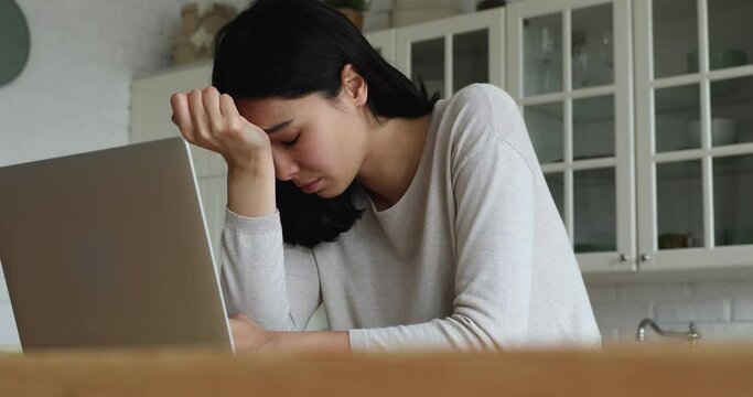 Young Asian woman read bad news on laptop look desperate, feels stressed due unsaved document, important data loss, notice form bank about debt, device malware, file error, work down the drain concept