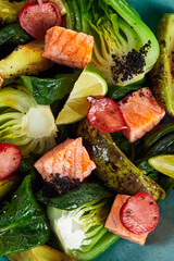 Salad with artichokes, avocado and salmon close-up, large segments of vegetables avocado artichokes and fried salmon cubes, close-up.