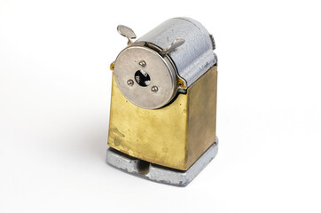 Vintage pencil sharpener on white background. Manual metal tool for sharpening wooden pencils.