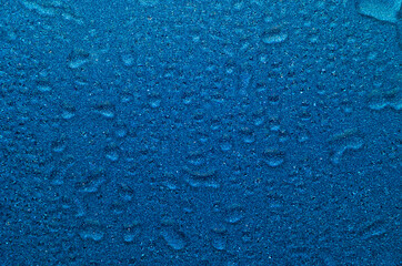Ultramarine shimmer glitter wet texture with drops and ripple. Bright water background.