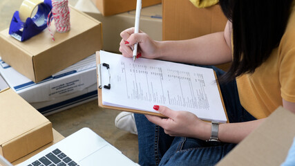 Woman checks stock files for shipping to customers, Online sales, Parcel delivery.
