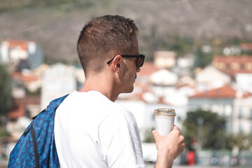 man with bag and coffee to go sightseeing
