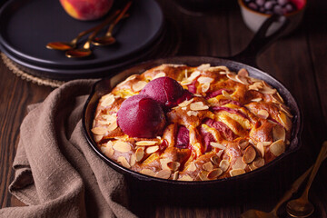 Homemade fruit cake with peaches, berries and almonds with berry sorbet on top. Dark mood photo....