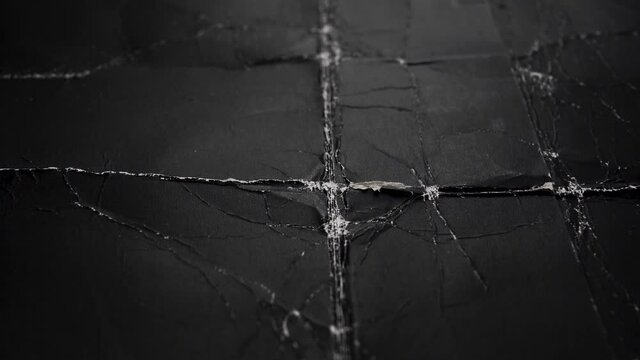 Black folded wrinkled worn paper with dusty folds. Grunge sheet cardboard