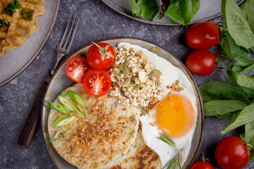 Potato pancakes with salad, avocado and tomatoes, Top view breakfast on a dark background