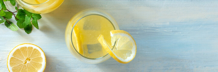 Lemonade panorama. Homemade fresh lemon juice, shot from the top on a wooden background with copy...