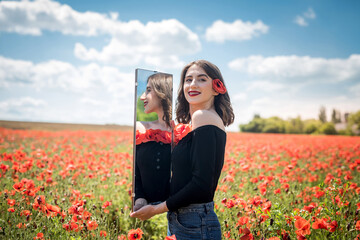 Young woman walking on red poppy field, summer time