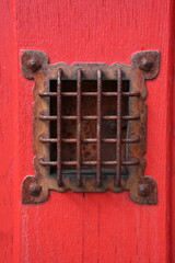 judas sur une vieille porte en bois rouge