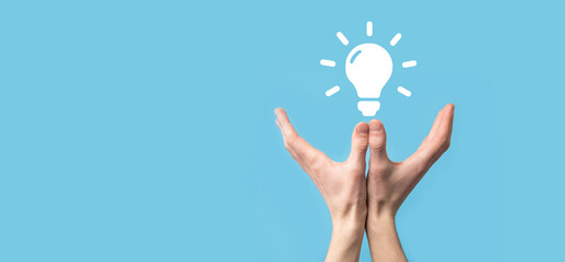 Hand hold light bulb. Holds a glowing idea icon in his hand. With a place for text.The concept of...
