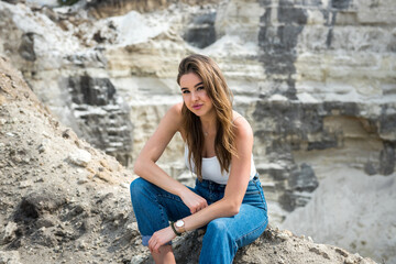  young female model posing and resting outside in sand quarry