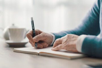 Senior woman writing on a notebook