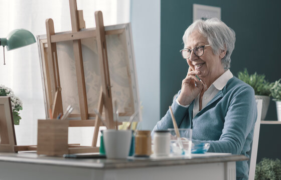 Happy Senior Lady Looking At Her Finished Artwork