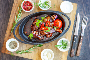 Roast meat with baked tomatoes and onions with sweet sauce, beautifully served in cast-iron dishes. Restaurant menu
