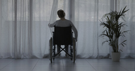 Woman in wheelchair at home alone