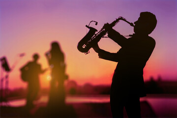 Silhouette twilight scene of Saxophone man showing as trio musicians. Background for celebrate...