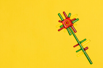 A glass flower on a bright yellow background.