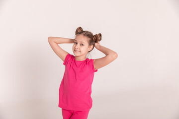portrait of a beautiful girl with tails in pink clothes on a white isolated background