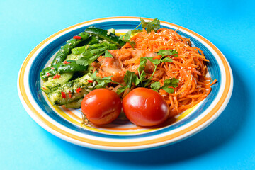 Fresh vegetable salad made of cabagge, carrot, cucumbers and tomatoes with fresh greenery.
