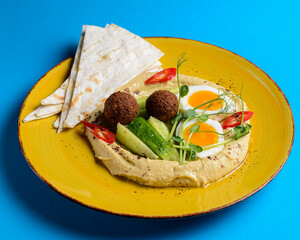 Healthy breakfast with fresh boiled eggs, cut cucumbers, sauce and lavash bread.