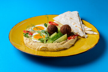 Healthy breakfast with fresh boiled eggs, cut cucumbers, sauce and lavash bread.